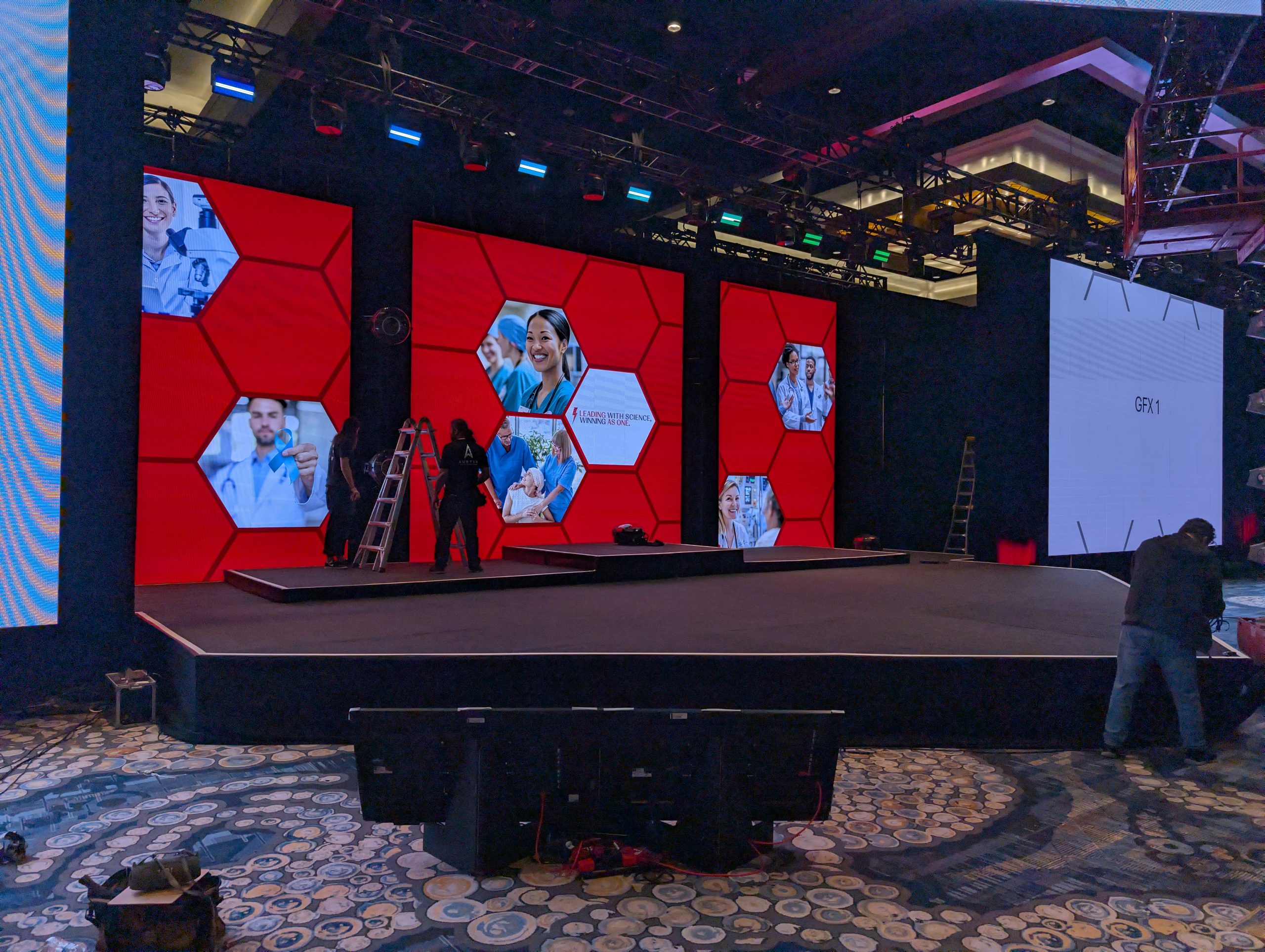 Chevron-shaped stage with LED wall, confidence monitors, full rigging, and intelligent lighting for a bold, tech-forward setup